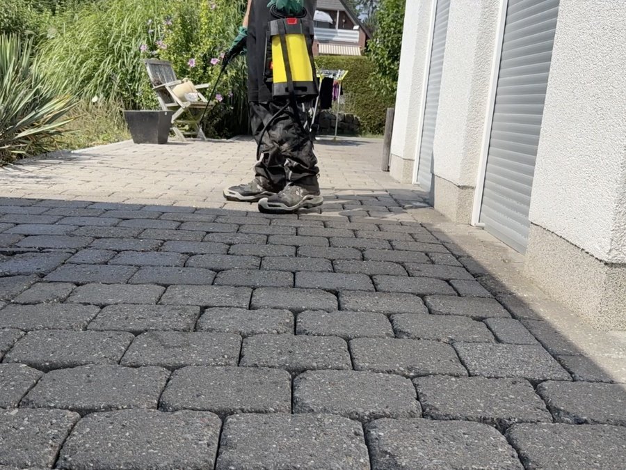 Imprägnierung wird mit der Rückenspritze auf Pflaster aufgetragen