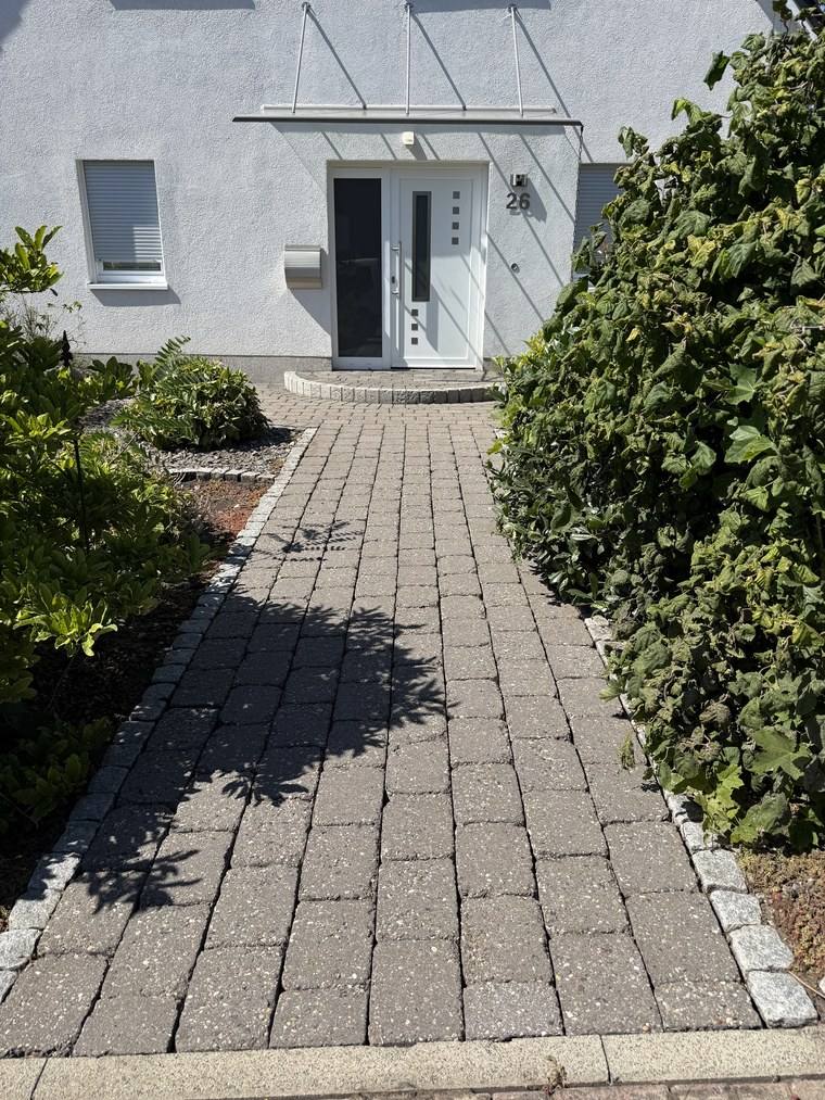 Derselbe Weg zur Haustür nach der Reinigung, die Steine gleichmäßig hell bis zur Stufe