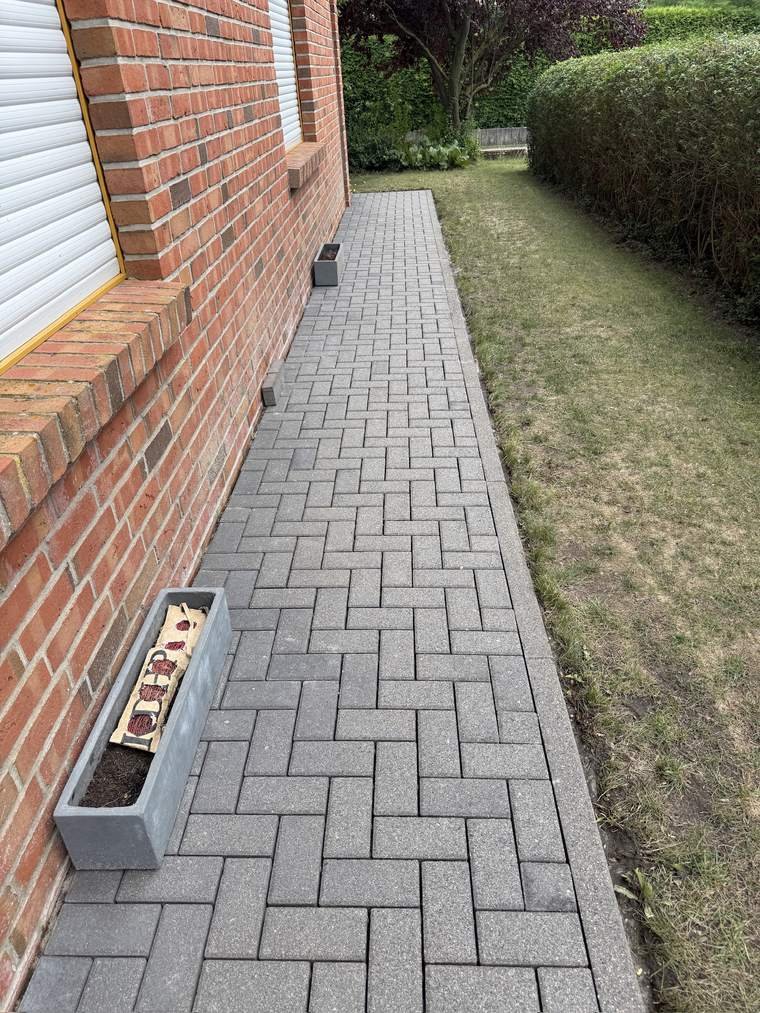 Derselbe Gehweg nach der Reinigung, Pflaster wieder gleichmäßig hell
