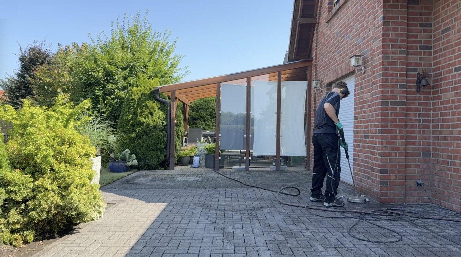Steinreinigung an einem Haus in Wolfsburg: Pflasterfläche wird mit dem rotierenden Flächenreiniger gesäubert