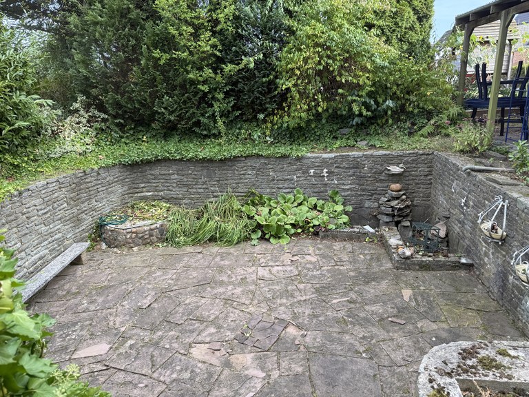 Derselbe Sitzplatz nach der Arbeit, die Bruchsteinfläche wieder frei und die Mauer vom Bewuchs befreit